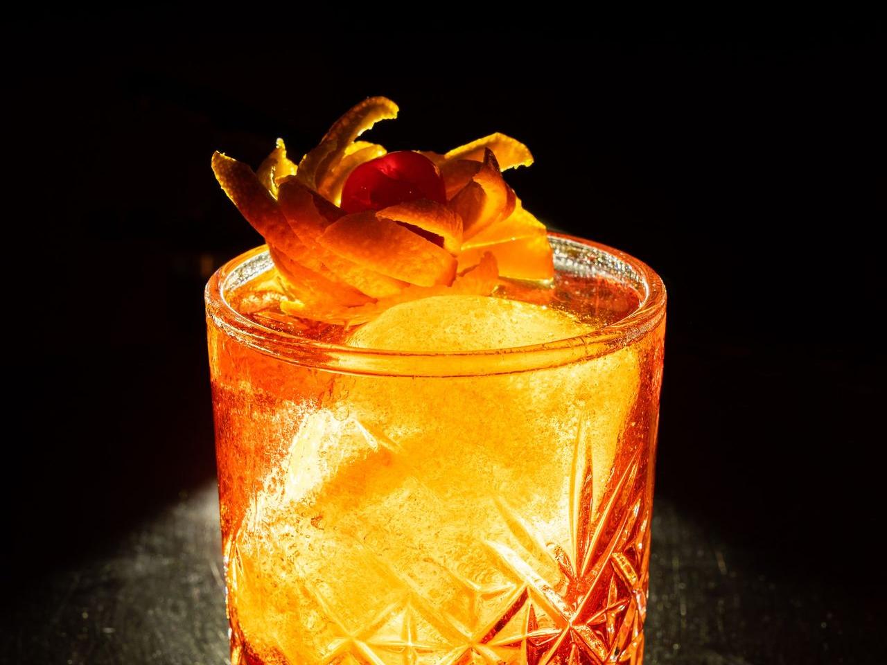 clear drinking glass with orange liquid and ice