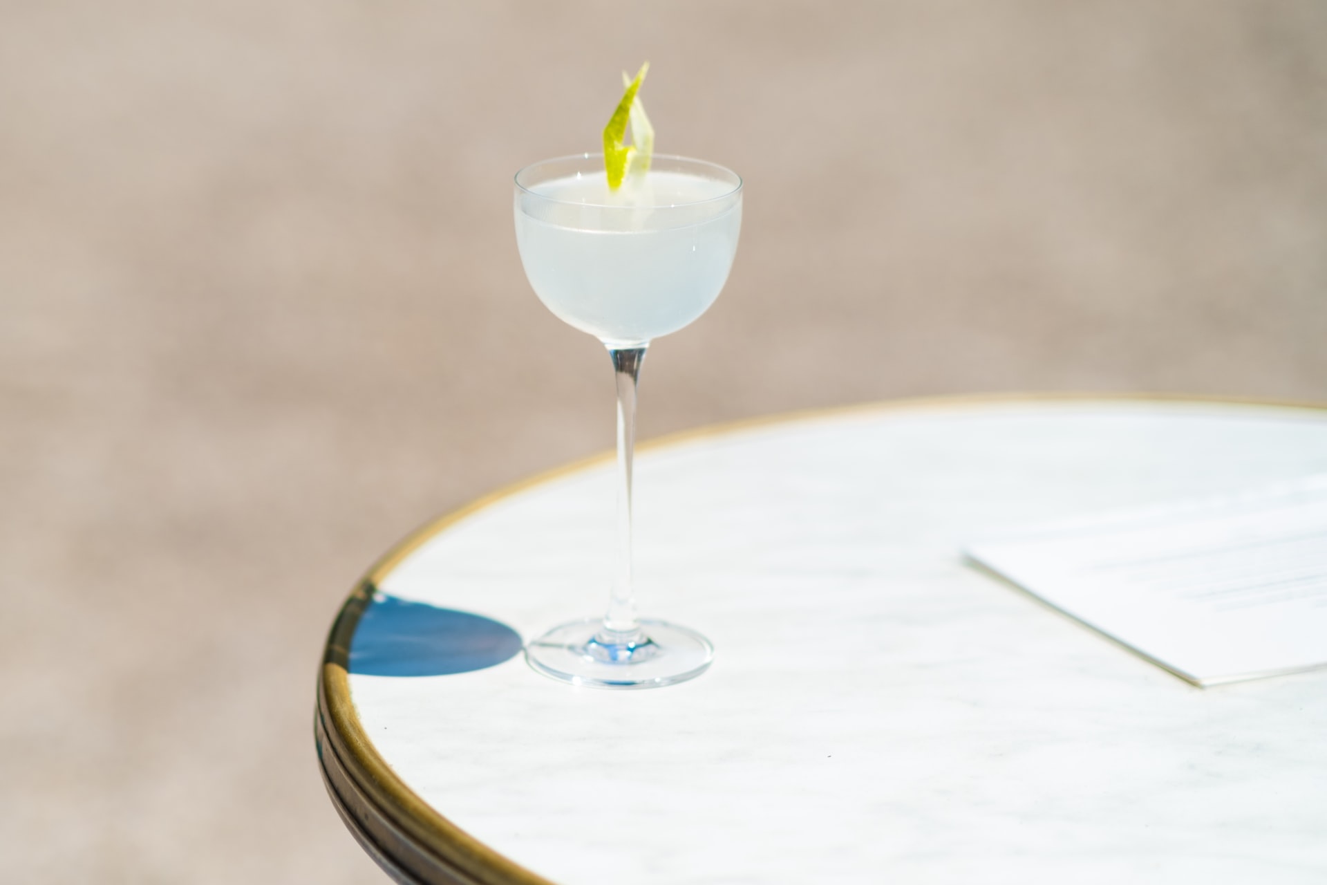 a glass of alcohol sitting on top of a table